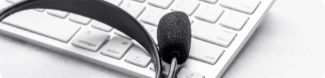 Un auricular apoyado sobre el teclado de una computadora
