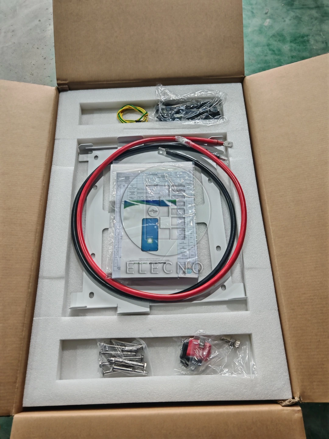Caja abierta con inserciones protectoras, cables de batería y accesorios empaquetados