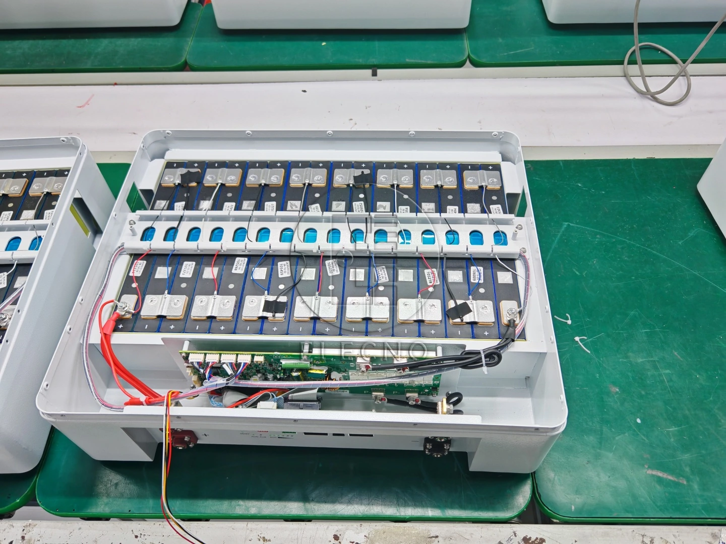Gabinete de batería abierto que muestra la disposición de las celdas y el cableado interno durante el ensamblaje