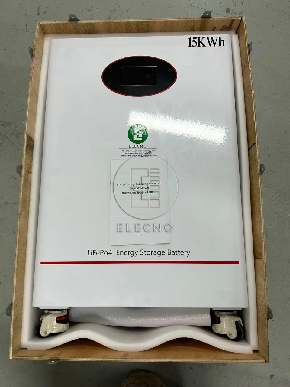 Una batería marcada como 15kWh protegida dentro de una caja de madera abierta.