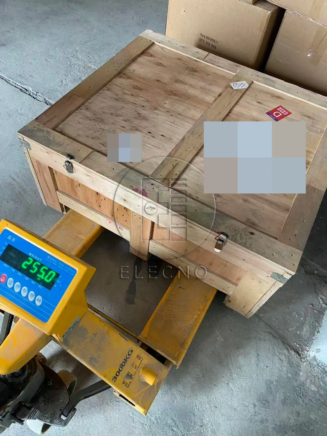 Caja de envío de baterías en el equipo de pesaje durante la preparación, con identificadores de cliente ocultos